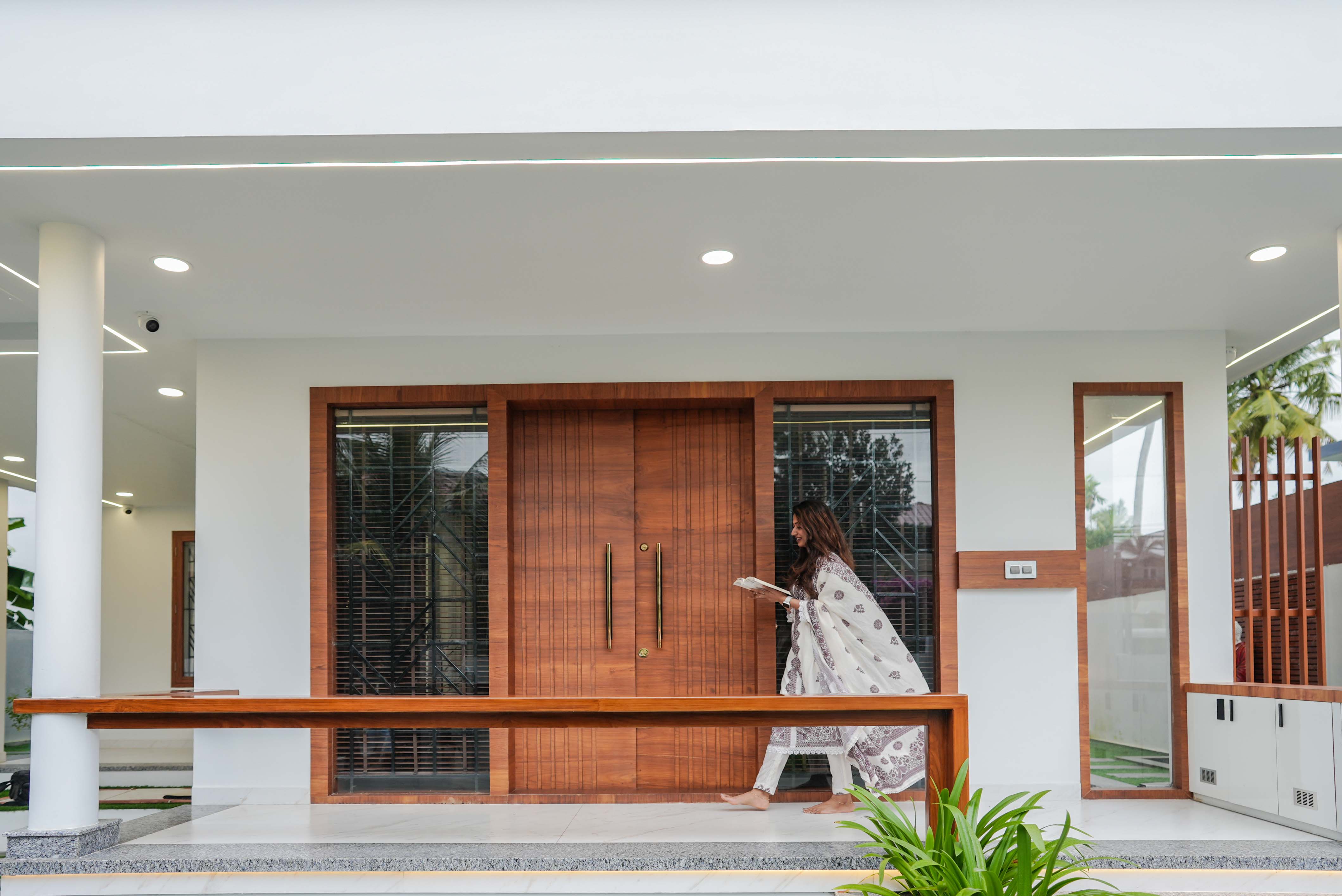Entrance porch at Sanpra Pranavam with wooden door and covered walkway