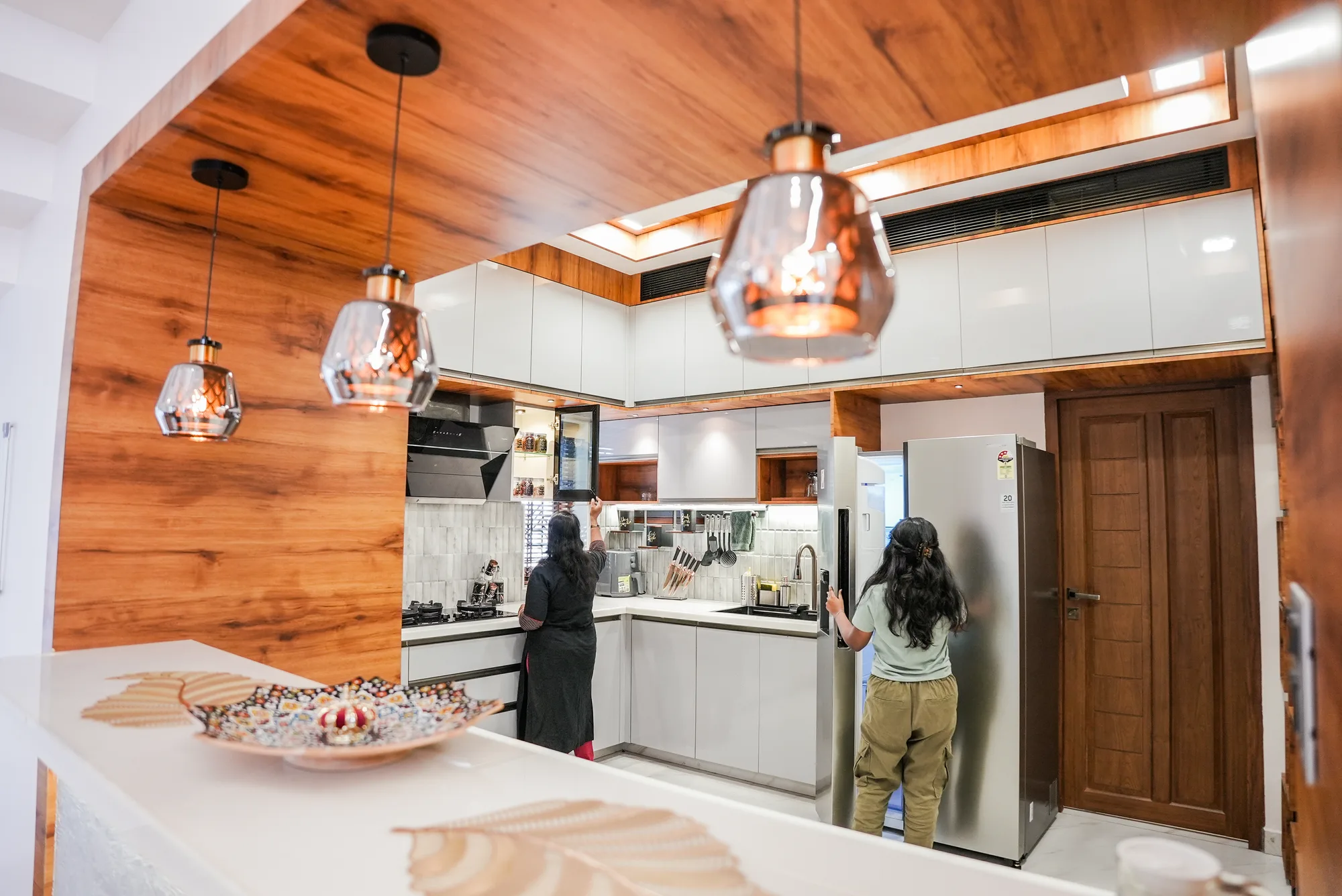 Kitchen interior at Sanpra Pranavam with wood ceiling and integrated storage