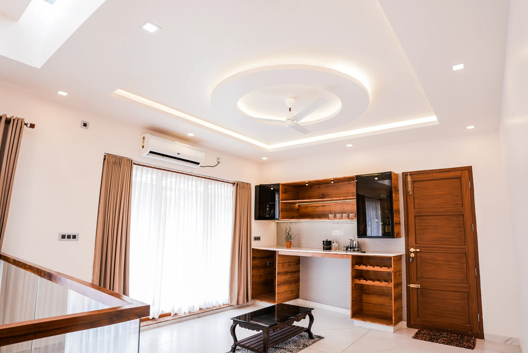 Living space with custom ceiling and built-in joinery at Sanpra Pranavam