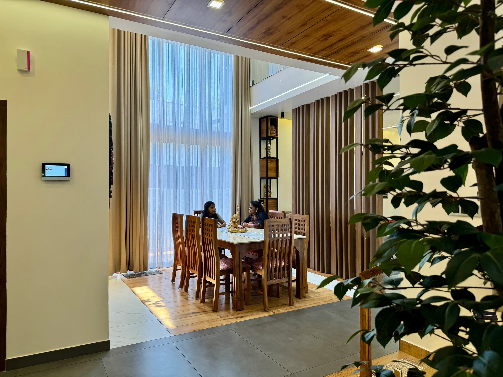 Dining area at Sanpra Pranavam with wood ceiling and natural light