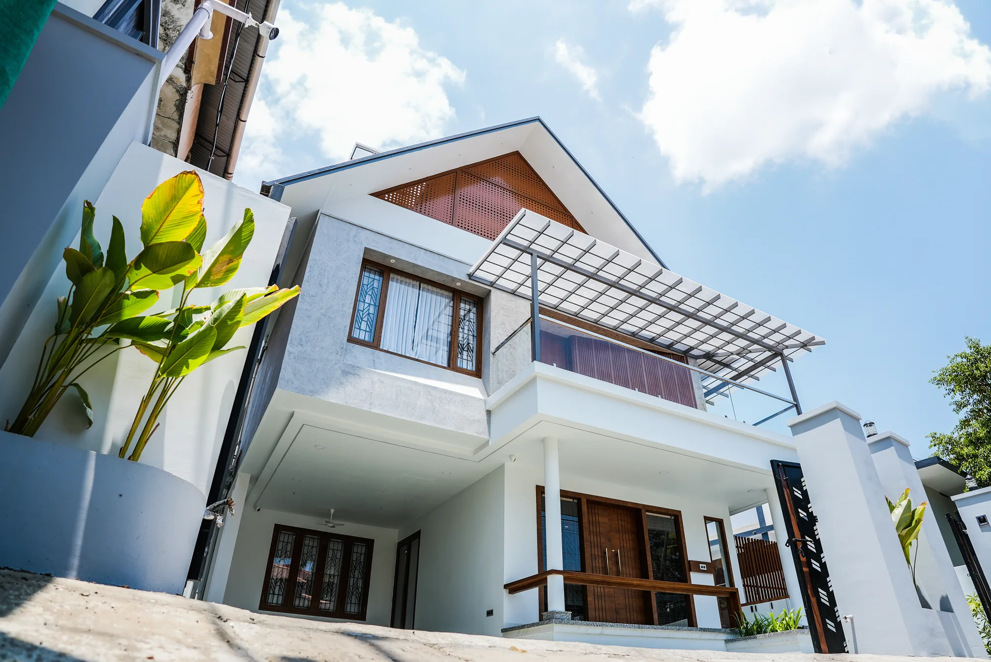 Completed exterior of Sanpra Pranavam showing cantilevered upper floor above the car porch